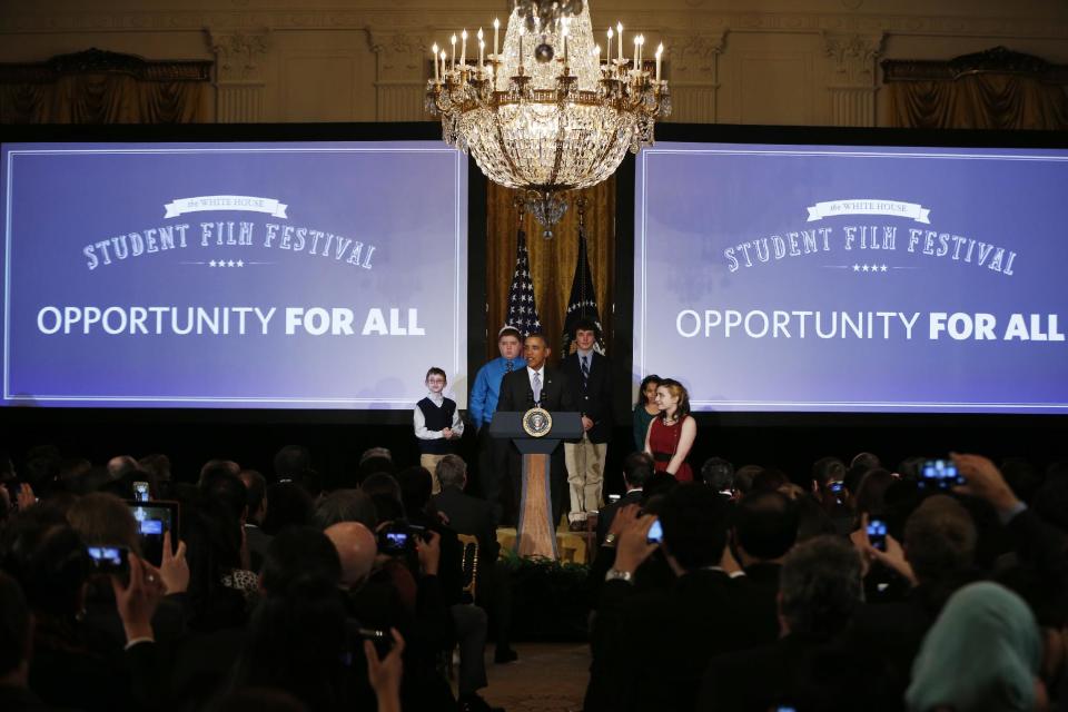 President Barack Obama speaks at the first White House Student Film Festival, Friday, Feb. 28, 2014, in the East Room at the White House in Washington. Student filmmakers pictured, Miles Pilchik, left, and Gabrielle Nafie, second right, second graders, SciTech in New York, Kids; Kyle Weintraub, second left, seventh grade, from David Posnack Jewish Day School in Davie, Fla.; and Shelly Ortiz, high school senior at Metropolitan Arts Institute, from Phoenix, Ariz. (AP Photo/Charles Dharapak)