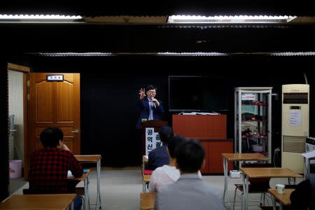 Moon Seoung-ok, president of the Headquarters of Reporting for Public Good, gives a lecture on how to earn money as a paparazzi during a class in Seoul, South Korea, September 30, 2016. REUTERS/Kim Hong-Ji