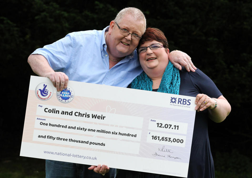 Colin Weir y la que era su esposa sosteniendo el cheque de 161 millones de libras ganadas en la lotería.