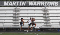 Student athletes run a drill during the re-opening of a strength and conditioning camp at Arlington Martin High School, Thursday, June 18, 2020, in Arlington, Texas. The summer football workouts at the school had been suspended after a student tested positive for COVID-19 but have resumed with safety guidance from the Tarrant County Public Health department and Arlington Public Health Authority. (AP Photo/LM Otero)