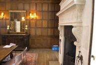 <p>Here’s a look at the home’s interior showing a grand fireplace and wood paneling on the walls. (Mashable Tech) </p>