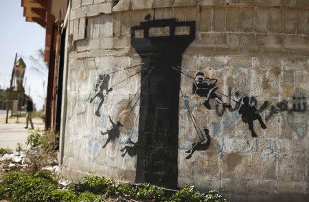A mural, presumably painted by British street artist Banksy, is seen on a wall in Biet Hanoun town in the northern Gaza Strip February 26, 2015. REUTERS/Suhaib Salem