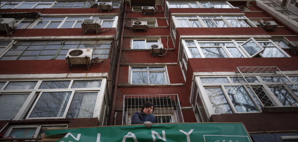 Worker changing a business signboard in downtown Beijing, China, Friday, March 7, 2014. China today expressed confidence over achieving its GDP target of 7.5 per cent this year, citing the expected recovery of the world economy and strong fundamentals of emerging markets. (AP Photo/Vincent Thian)