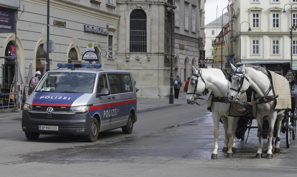 A police van drives past Fiaker horses at St. Stephen's cathedral in Vienna, Austria, Wednesday, Mar 15, 2023. Austrian police are warning of a possible “Islamist-motivated attack” targeting churches in Vienna. They cited undisclosed information the country’s intelligence service had received. (AP Photo/Heinz-Peter Bader)