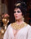 <p>The industry has so much to thank <em>Cleopatra </em>for — from Liz & Dick to Taylor's iconic wardrobe throughout the blockbuster film. Joseff of Hollywood, the jeweler behind many of Hollywood's <a href="https://www.townandcountrymag.com/style/jewelry-and-watches/a13136532/elizabeth-taylor-cleopatra-jewelry/" rel="nofollow noopener" target="_blank" data-ylk="slk:biggest films at the time;elm:context_link;itc:0;sec:content-canvas" class="link ">biggest films at the time</a>, fitted the actress in pieces like this plated gold bib necklace, chandelier earrings, and hair piece.  </p>