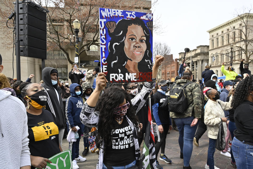 FILE - In this March 13, 2021 file photo, a protester holds up a painting of Breonna Taylor during a rally on the one year anniversary of her death at Jefferson Square Park in Louisville, Ky. On Friday, April 9, 2021, Gov. Andy Beshear has signed a partial ban on no-knock warrants a year after the fatal shooting of Taylor. (AP Photo/Timothy D. Easley)