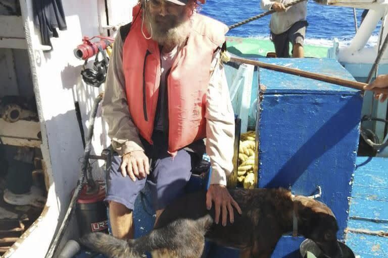 En esta fotografía proporcionada por Grupomar/Atun Tuny, el australiano Tim Shaddock permanece sentado con su perra Bella tras ser rescatado por un buque atunero mexicano en aguas internacionales del Pacífico, luego de que navegó a la deriva con Bella en su catamarán averiado durante tres meses. (Grupomar/Atun Tuny vía AP)