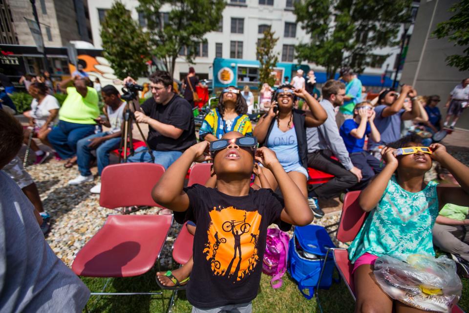 People use special glasses to view the sun during the solar eclipse watch party at the downtown branch of the St. Joseph County Public Library in South Bend on Monday, Aug. 21, 2017.
