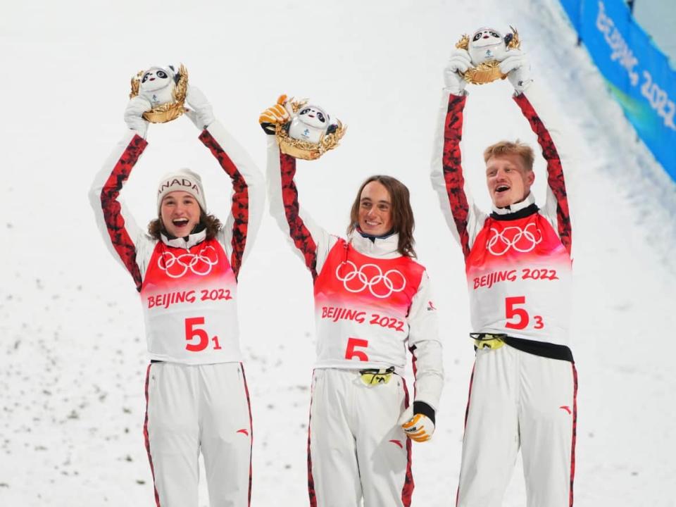 Canada's (left to right) Marion Thenault, Miha Fontaine and Lewis Irving celebrate on the podium after winning the bronze medal in the freestyle skiing mixed team aerials event at the Beijing Olympic Winter Games, on Thursday in Zhangjiakou, China. (Sean Kilpatrick/The Canadian Press - image credit)