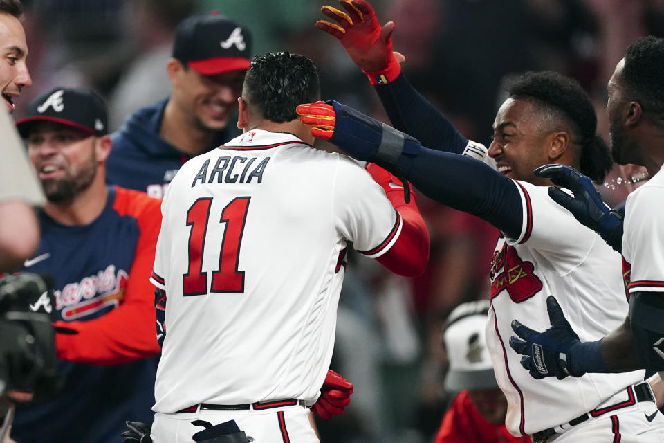 Atlanta Braves' Orlando Arcia (11) is mobbed by teammates after hitting a two-run walkout home run in the ninth inning of a baseball game against the Boston Red Sox Wednesday, May 11, 2022, in Atlanta. (AP Photo/John Bazemore)