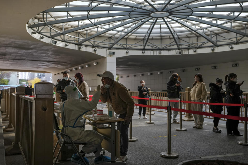 People wearing face masks stand in line for their routine COVID-19 tests at a coronavirus testing site setup at a tunnel in the central business district of Beijing, Wednesday, Nov. 16, 2022. Chinese authorities locked down a major university in Beijing on Wednesday after finding one COVID-19 case as they stick to a "zero-COVID" approach despite growing public discontent. (AP Photo/Andy Wong)