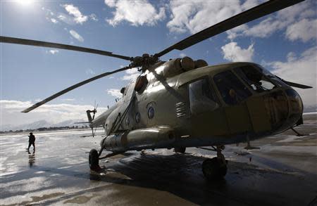 An Afghan soldier walks next to a refurbished Mi-17 helicopter at the military airport in Kabul in this file photo taken January 17, 2008. REUTERS/Ahmad Masood/Files