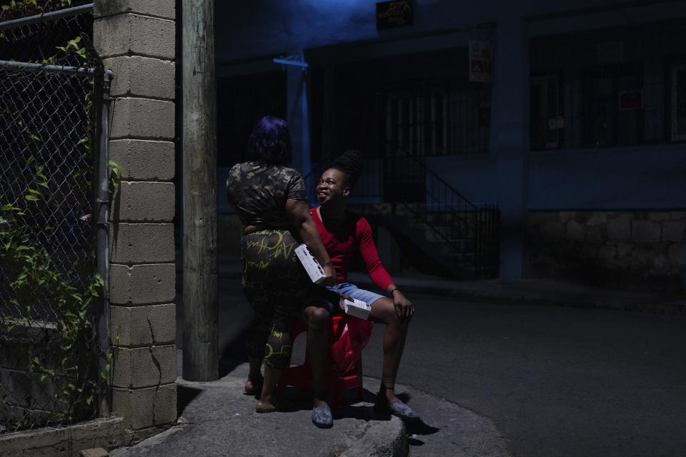 Orden David talks with a local sex worker he is friendly with while distributing condoms and lubricant to the women, early Saturday, May 13, 2023, in St. John's, Antigua. (AP Photo/Jessie Wardarski)
