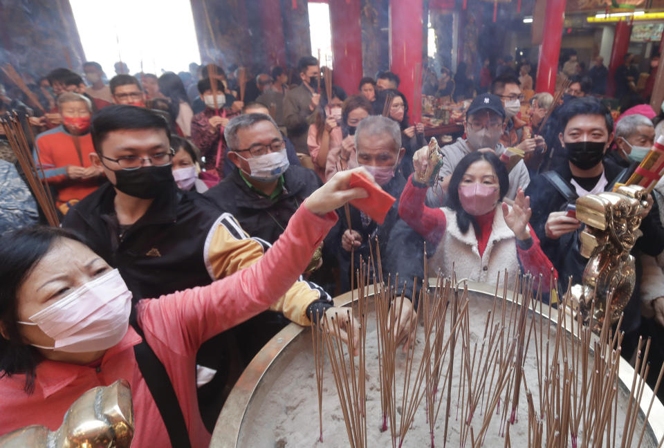 Worshippers wear face masks to help curb the spread of the coronavirus and pray for blessing at a temple on the first day of the Lunar New Year celebrations in Taipei, Taiwan, Sunday, Jan. 22, 2023. Each year is named after one of the 12 signs of the Chinese zodiac in a repeating cycle, with this year being the Year of the Rabbit. (AP Photo/Chiang Ying-ying)