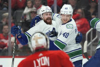 Vancouver Canucks center Elias Pettersson (40) celebrates his goal with Filip Hronek (17) against the Detroit Red Wings in the second period of an NHL hockey game Saturday, Feb. 10, 2024, in Detroit. (AP Photo/Paul Sancya)