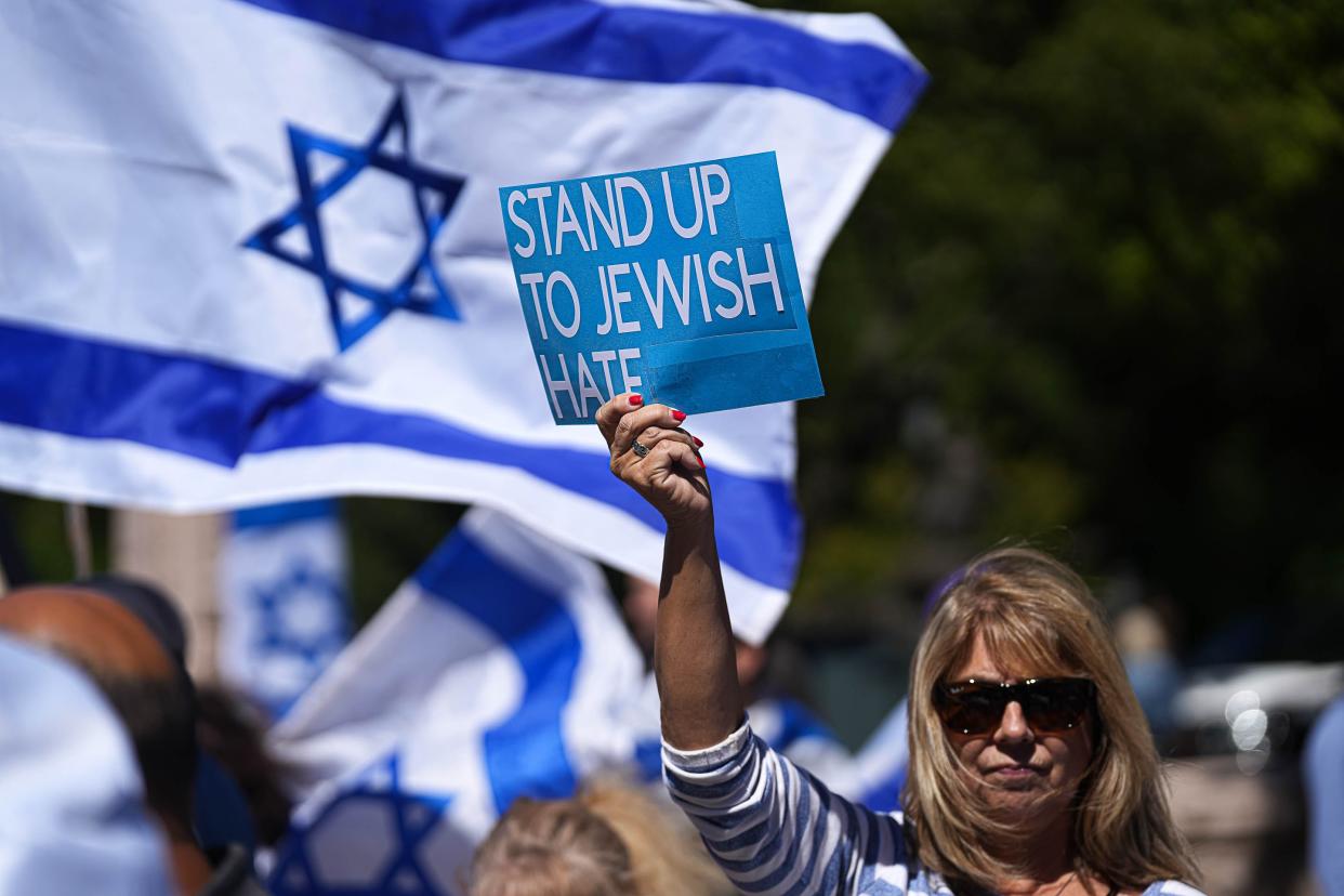 Kathy Tee holds up a sign condemning antisemitism at a solidarity rally for Israel outside the Texas Capitol this month. "I'm here because I wanted to support the Jewish people and I didn't want to stay silent," Tee said.