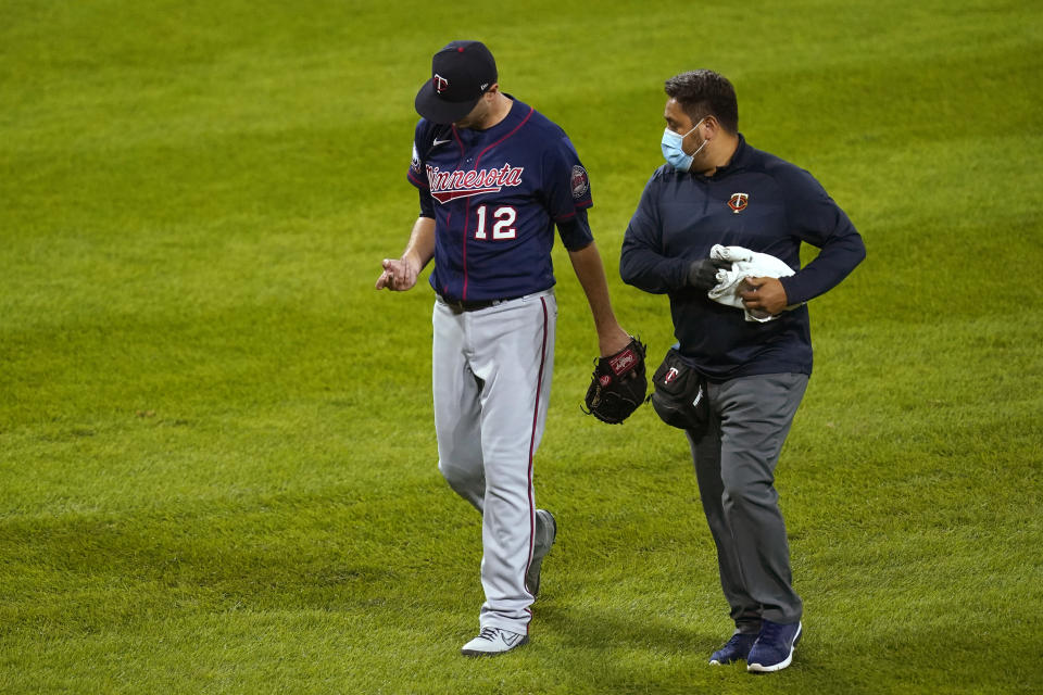 Minnesota Twins starting pitcher Jake Odorizzi looks at his pitching hand as he leaves the baseball game with a trainer during the fourth inning against the Chicago White Sox on Wednesday, Sept. 16, 2020, in Chicago. (AP Photo/Charles Rex Arbogast)