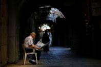 A man sits in an alley in the Christian Quarter of Jerusalem's Old City June 21, 2016. REUTERS/Ronen Zvulun
