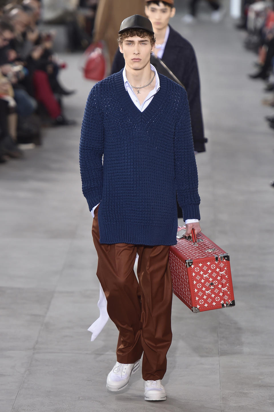 <p>Another major item from the Louis Vuitton-Supreme collection is the monogrammed trunk juxtaposed with a very “hypebeast” style outfit: baseball cap, oversize sweater, baggy trousers, and crisp white sneakers. (Photo: Catwalking) </p>