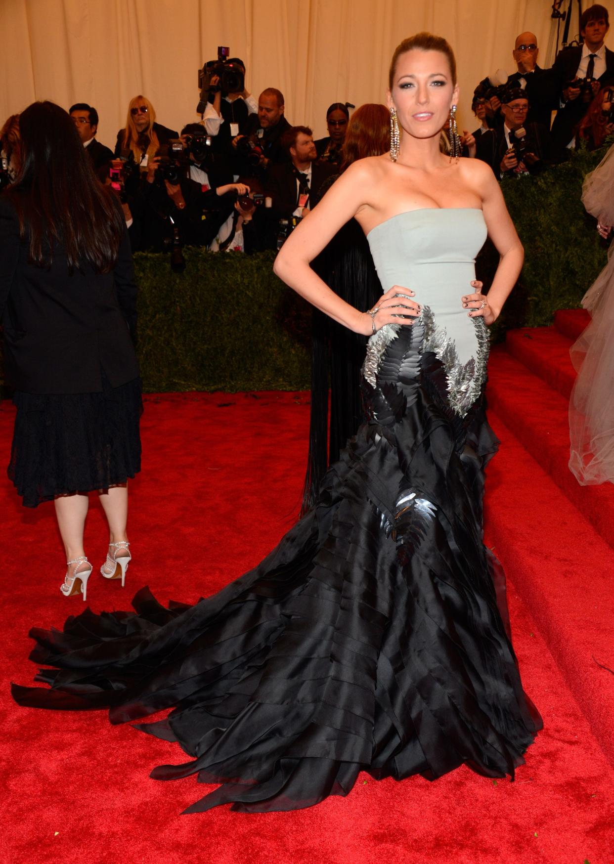 Blake Lively at the 2013 Met Gala in a gown with a gray top and black bottom.