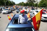 Un manifestante con mascarilla sostiene una bandera de España durante una manifestación en Madrid