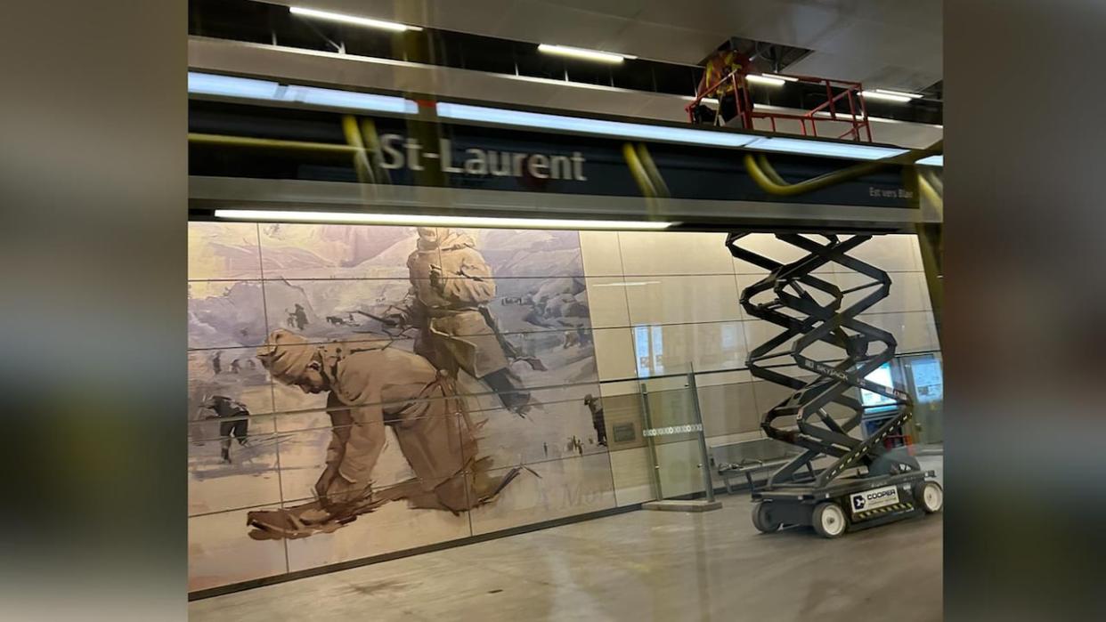 A worker at St-Laurent LRT station on Friday looks into the ceiling tiles above the platform. The City of Ottawa says LRT trains are temporarily skipping the station after inspectors discovered issues with the tiles. (Philip Ling/CBC - image credit)