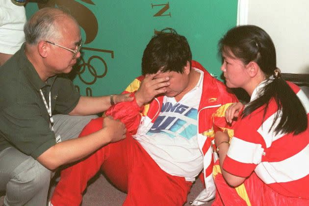 ATLANTA, GA - JULY 20:  China's Wang Yifu is attended by Chinese team officials after he collapsed during the shooting event at the Wolf Creek Shooting Complex, near Atlanta, 20 July. Wang, who was in the lead, missed his final shot and collapsed, to take silver. (FOR EDITORIAL USE ONLY) AFP/IOPP/Michel GANGNE  (Photo credit should read MICHEL GANGNE/AFP via Getty Images) (Photo: MICHEL GANGNE via Getty Images)