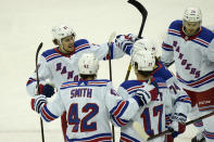 New York Rangers' Brett Howden, left, celebrates with teammates after assisting a goal by Vitali Kravtsov during the first period of the NHL hockey game against the New Jersey Devils in Newark, N.J., Sunday, April 18, 2021. (AP Photo/Seth Wenig)
