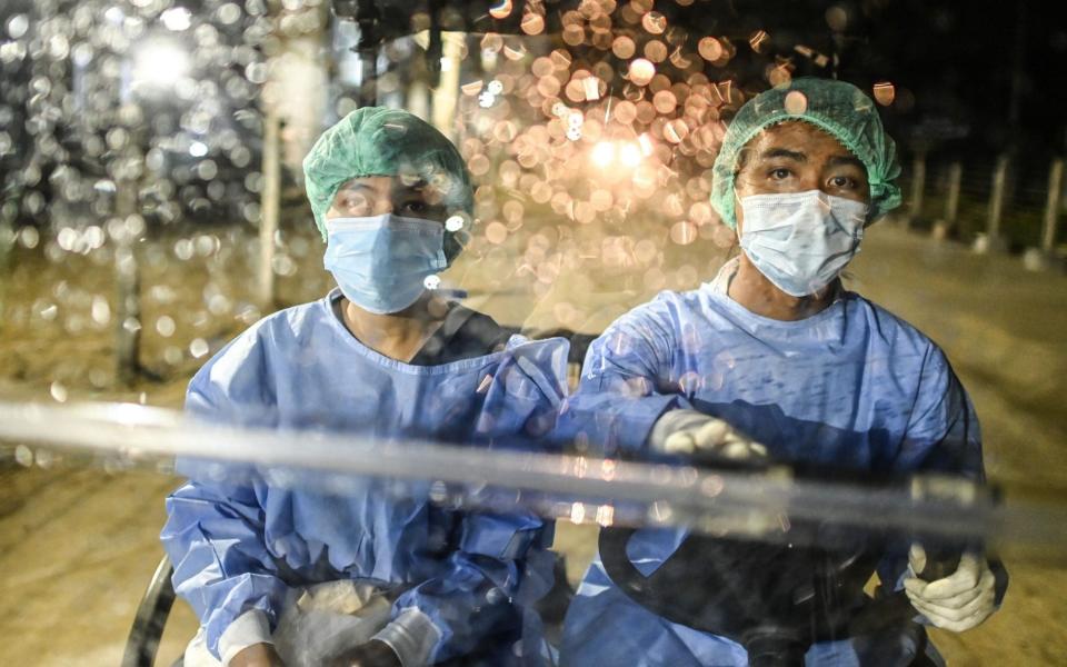 Health workers in Myanmar ride on a golf cart through a quarantine centre - Ye Aung Thu/AFP