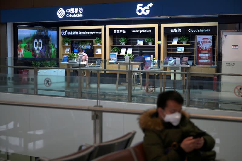 FILE PHOTO: Staff member wears a face mask inside a China Mobile store at the Beijing Daxing International Airport, as the country is hit by an outbreak of the novel coronavirus, in Beijing