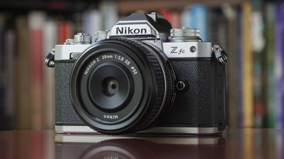 The Nikon Zfc camera on a red table in front of a bookcase