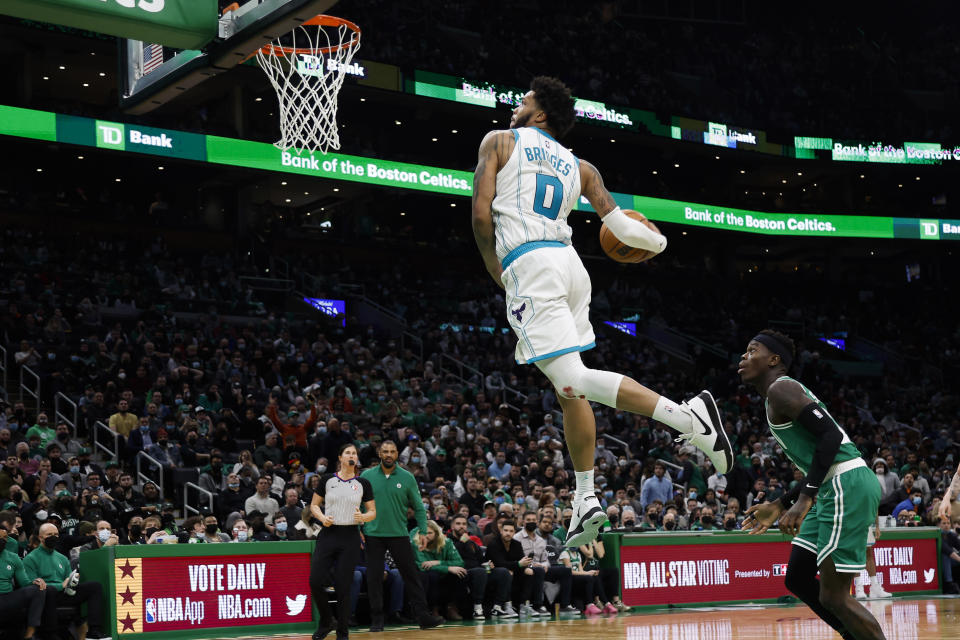 Charlotte Hornets' Miles Bridges goes up for a dunk as Boston Celtics' Dennis Schroder looks on during the second half of an NBA basketball game Wednesday, Jan. 19, 2022, in Boston. (AP Photo/Winslow Townson)