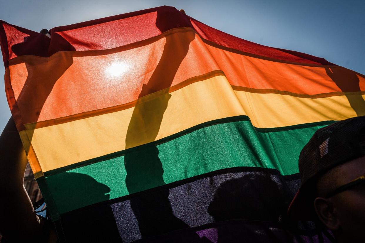 Pride activists fly an LGBT+ flag at a march in South Africa: Getty