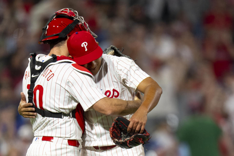 Philadelphia Phillies starting pitcher Ranger Suarez, right, hugs catcher J.T. Realmuto, left, following the baseball game against the Colorado Rockies, Tuesday, April 16, 2024, in Philadelphia. The Phillies won 5-0. (AP Photo/Chris Szagola)