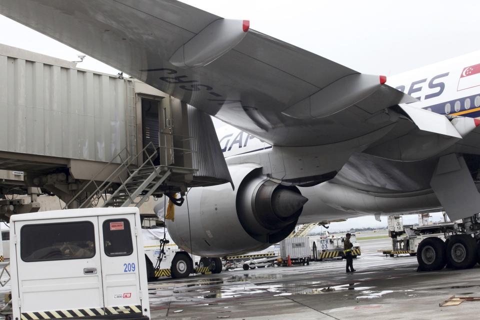 The left wing of a Singapore Airlines passenger plane touches an aerobridge at the Ninoy Aquino International Airport at the onslaught of Typhoon Rammasun, in Paranaque