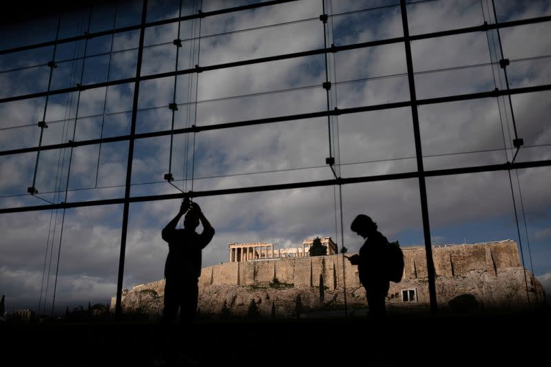 FILE PHOTO: Visitors take pictures of the Parthenon temple seen in the background, as they visit the Parthenon Gallery of the Acropolis Museum, in Athens