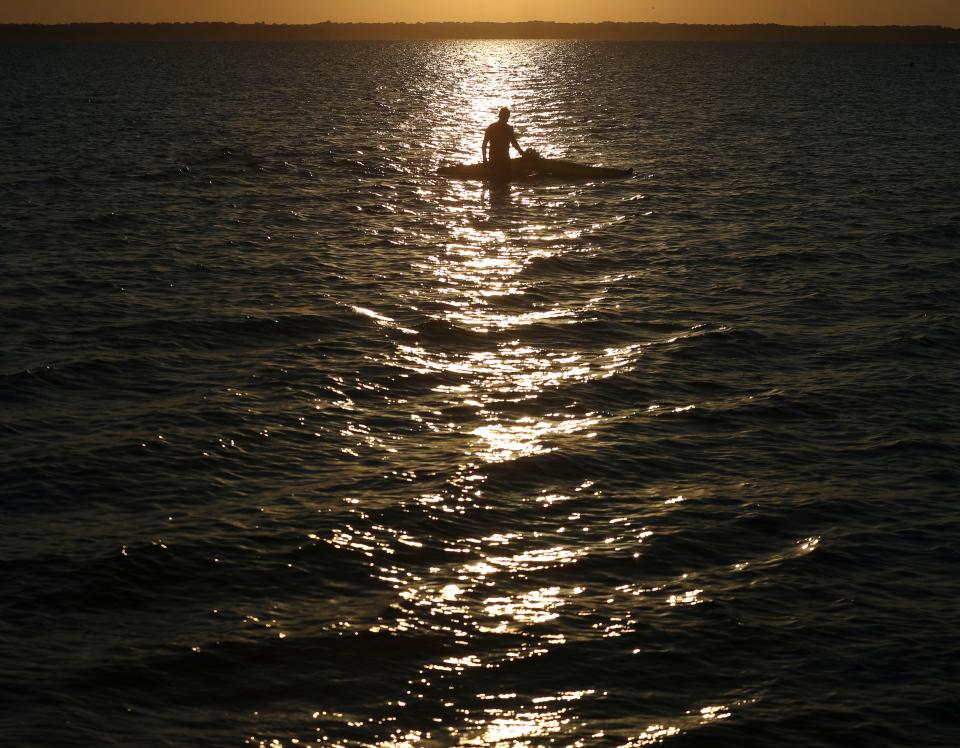 A man pulls in his windsurf sail on the Rehoboth Bay off the Delaware Seashore State Park as the sun heads for the horizon, Saturday, Sept. 2, 2023 during the unofficial end to summer, Labor Day Weekend.