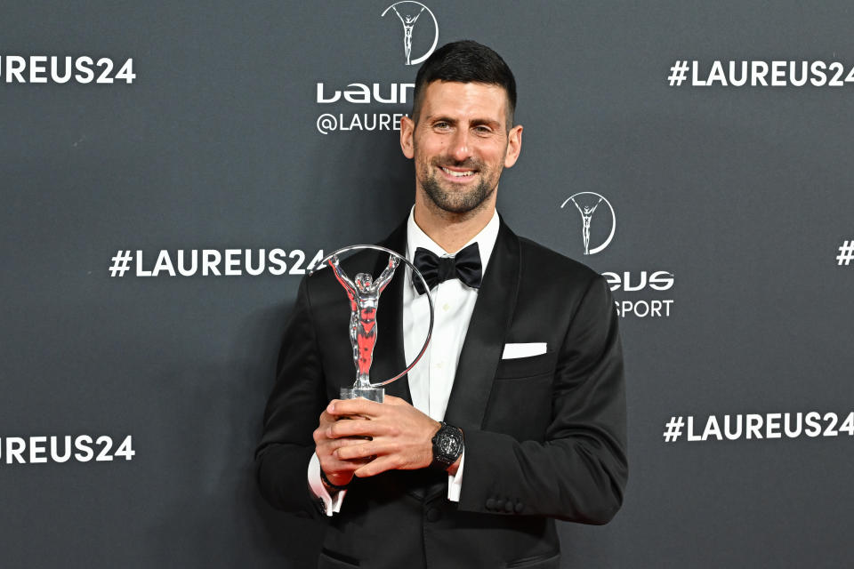 Novak Djokovic celebrates with the trophy.