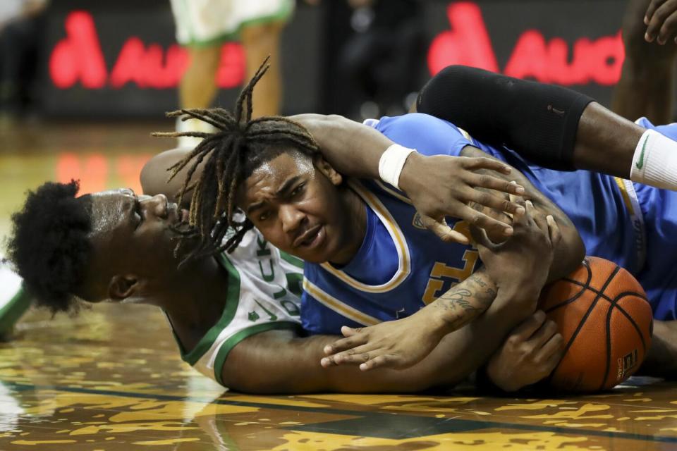 Oregon forward Mahamadou Diawara, left, and UCLA guard Brandon Williams, right, battle for the ball.