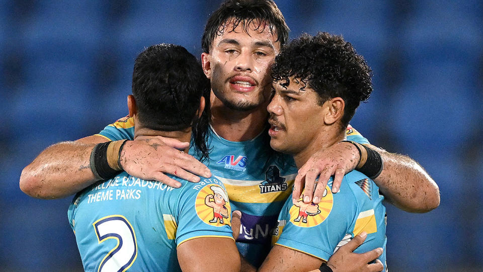 Tino Fa'asuamaleaui embraces two teammates.