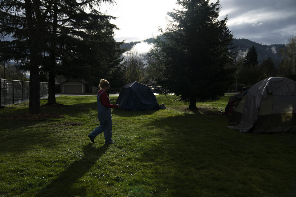 Cassy Leach, a nurse, who leads a group of volunteers who provide food, medical care and other basic goods to the hundreds of homeless people living in the parks, walks to help homeless people camping in Fruitdale Park move their tents on Saturday, March 23, 2024, in Grants Pass, Ore. (AP Photo/Jenny Kane)
