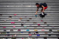 <p>Lorelei Williams places one of 215 pairs of children's shoes on the steps of the Vancouver Art Gallery as a memorial to the 215 children whose remains have been found buried at the site of a former residential school in Kamloops, in Vancouver, on Friday, May 28, 2021. Chief Rosanne Casimir of the Tk’emlups te Secwépemc First Nation said in a news release Thursday that the remains were confirmed last weekend with the help of a ground-penetrating radar specialist. THE CANADIAN PRESS/Darryl Dyck</p> 