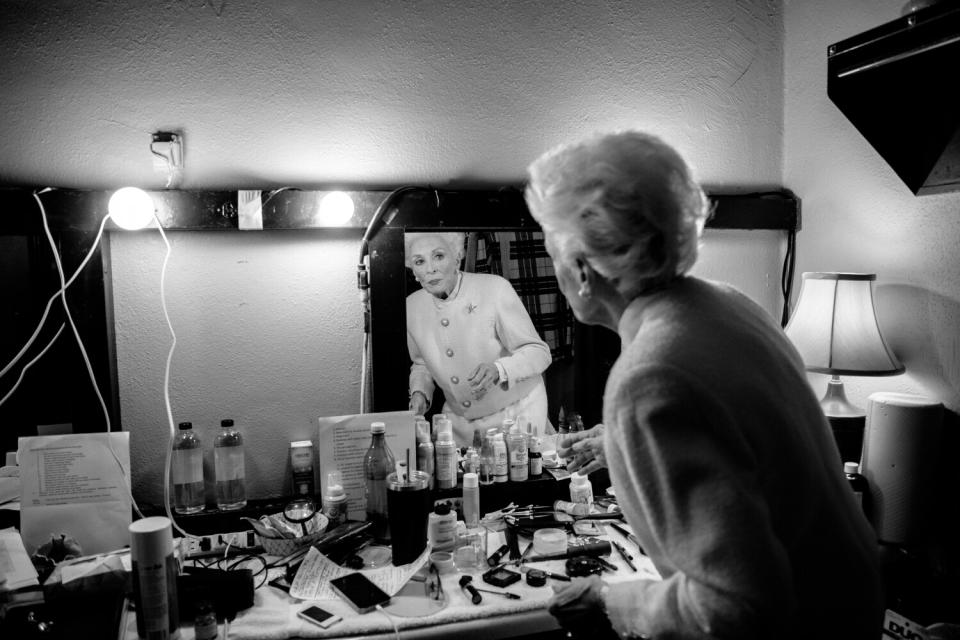 Taylor looks at herself in the mirror in a dressing room.