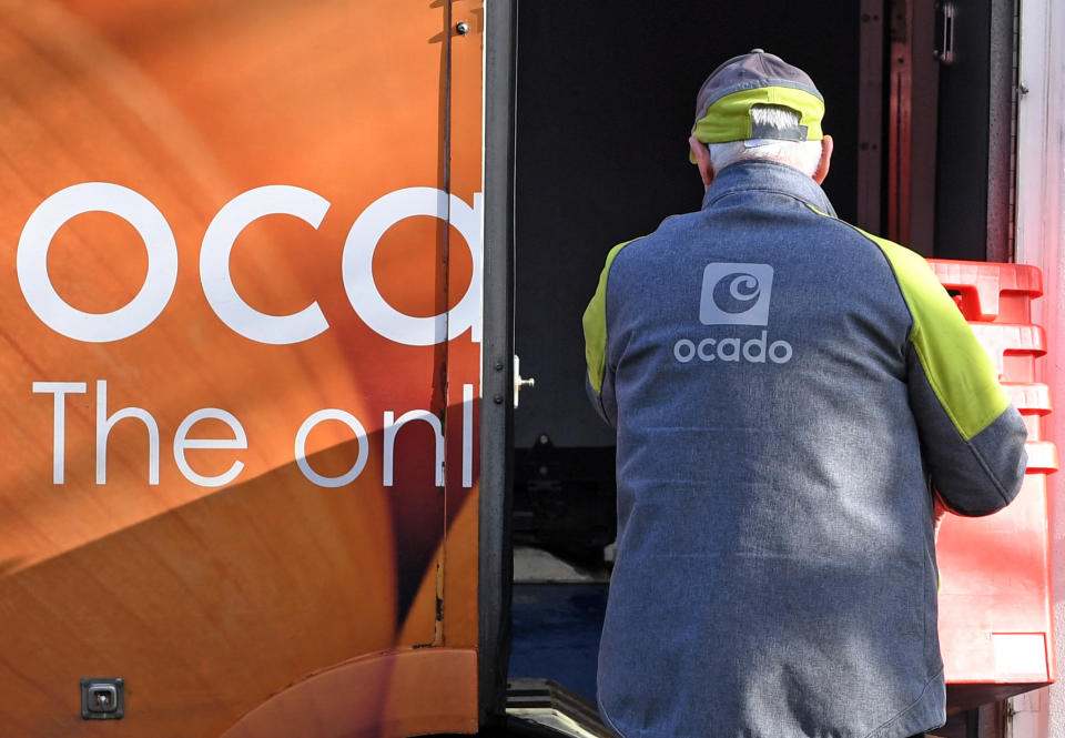 A delivery driver returns empty crates to his Ocado delivery van after supplying a residential address near Liverpool in north west England during a delivery of food and drink for supermarket Waitrose. Photo: Paul Ellis/AFP/Getty Images