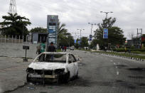 A burnt out car is seen on Lekki road in Lagos Friday, Oct. 23, 2020. Resentment lingered with the smell of charred tires Friday as Nigeria's streets were relatively calm after days of protests over police abuses, while authorities gave little acknowledgement to reports of the military killing at least 12 peaceful demonstrators earlier this week. (AP Photo/Sunday Alamba)