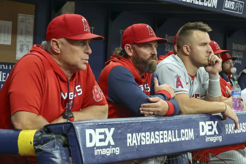 Los Angeles Angels' interim manager Phil Nevin, pitching coach Jeremy Reed and Mike Trout look on during the first inning of a baseball game against the Tampa Bay Rays Tuesday, Aug. 23, 2022, in St. Petersburg, Fla. (AP Photo/Mike Carlson)