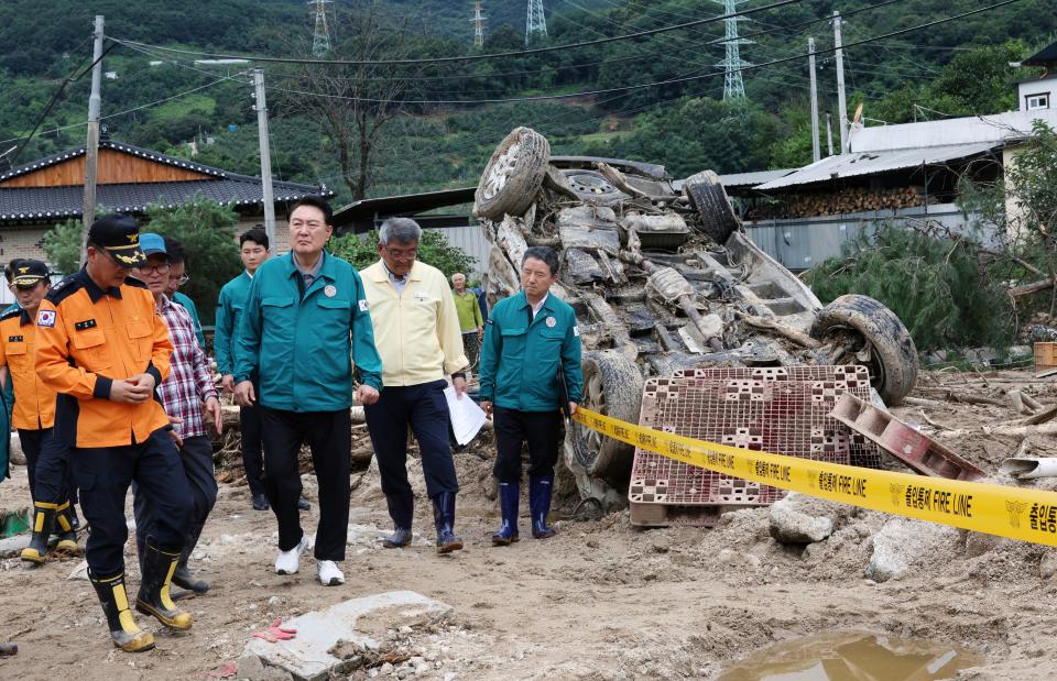 South Korean President Yoon Suk Yeol, fourth from left, looks around a flood damaged area in Yecheon, South Korea, Monday, July 17, 2023. (Jin Sung-chul/Yonhap via AP)