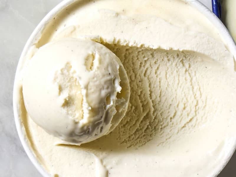 overhead shot of a carton of Tillamook vanilla bean ice cream, with the lid off and sitting to the right of the pint.