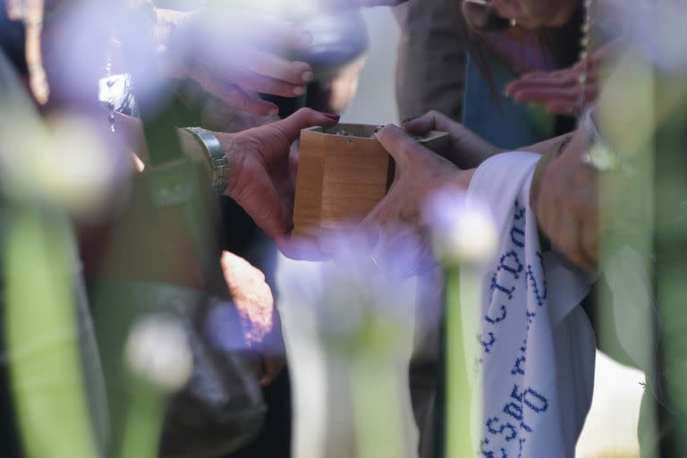 Miembros de las organizaciones de derechos humanos Madres de la Plaza de Mayo e H.I.J.O.S preparan las cenizas de Hebe de Bonafini para esparcilas en la Plaza de Mayo en Buenos Aires, en Argentina, el jueves 24 de noviembre de 2022. Bonafini, que se conviritió en una activista de derechos humanos cuando sus dos hijos fueron detenidos y desaparecidos bajo la dictadura militar argentina, murió el 20 de noviembre a los 93 años. (AP Foto/Gustavo Garello)