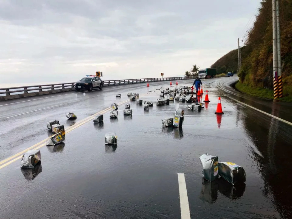 南迴公路一輛貨運曳引車上一百多桶沙拉油鬆脫掉落，沙拉油灑滿路面。（記者鄭錦晴翻攝）